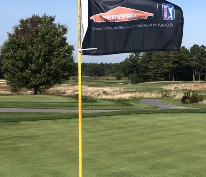a golf course with a SERVPRO flag coming out of the hole