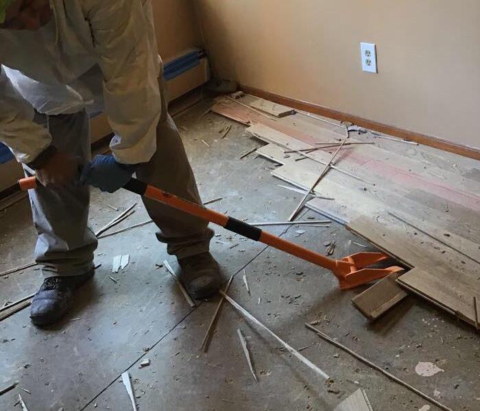 a man removing wood flooring 