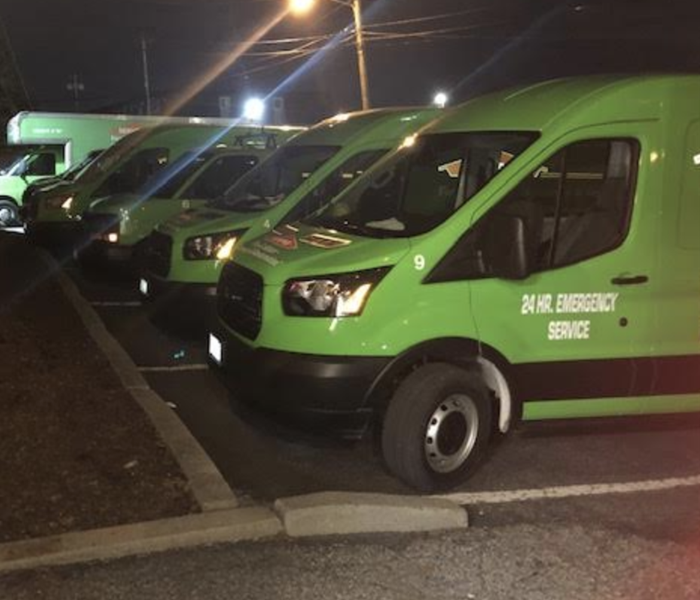 green SERVPRO vans parked on the street